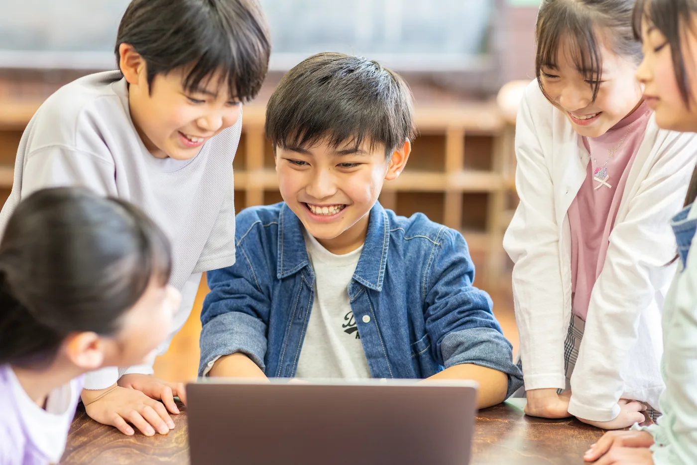 パソコンを囲んで学ぶ小学生たち